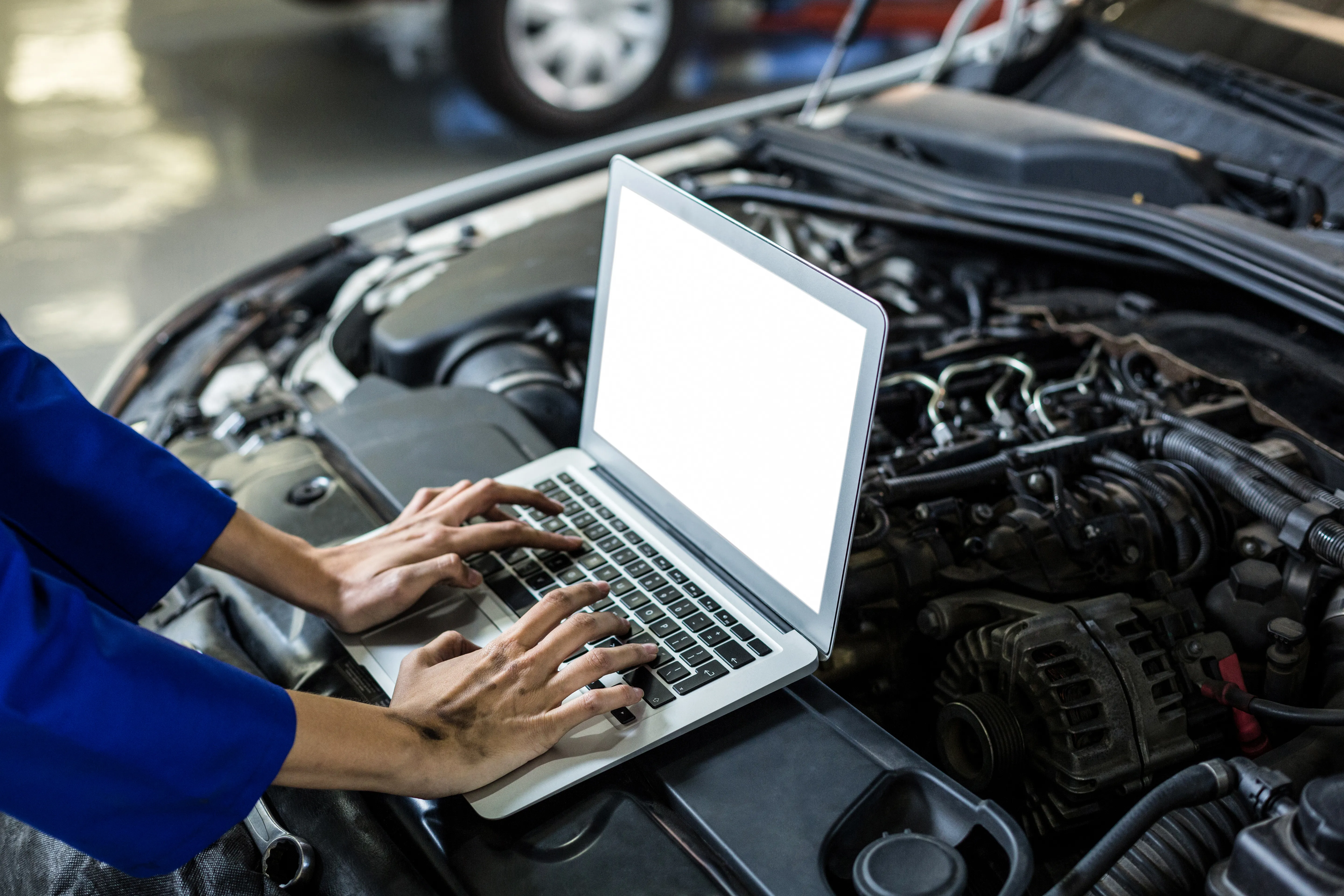Symbolfoto: Diagnose mit Laptop am geöffneten Motorraum