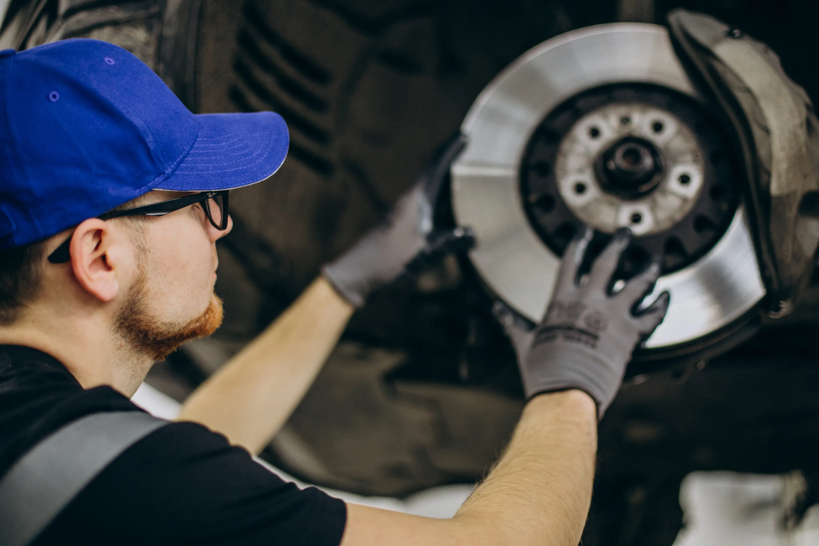 Symbolfoto: Mechaniker montiert eine Bremsscheibe